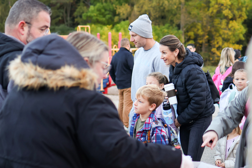 a family lined up to get donuts outside a school