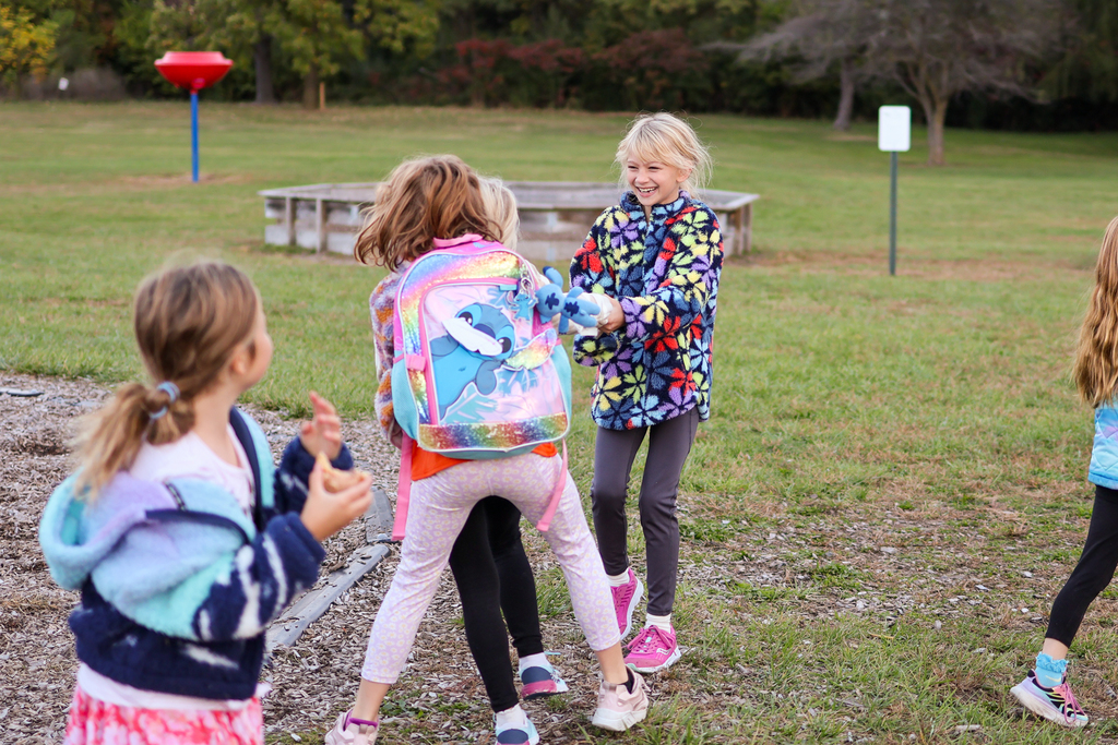 girls playing outside in the grass