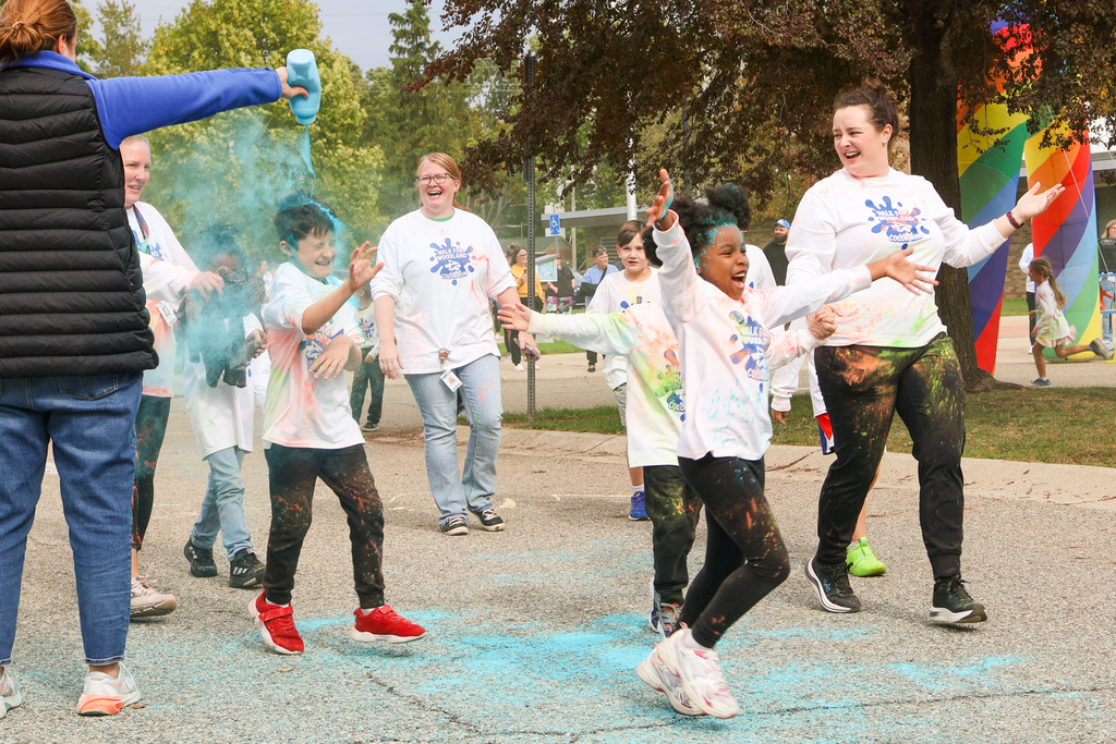 students running through blue powder outside 