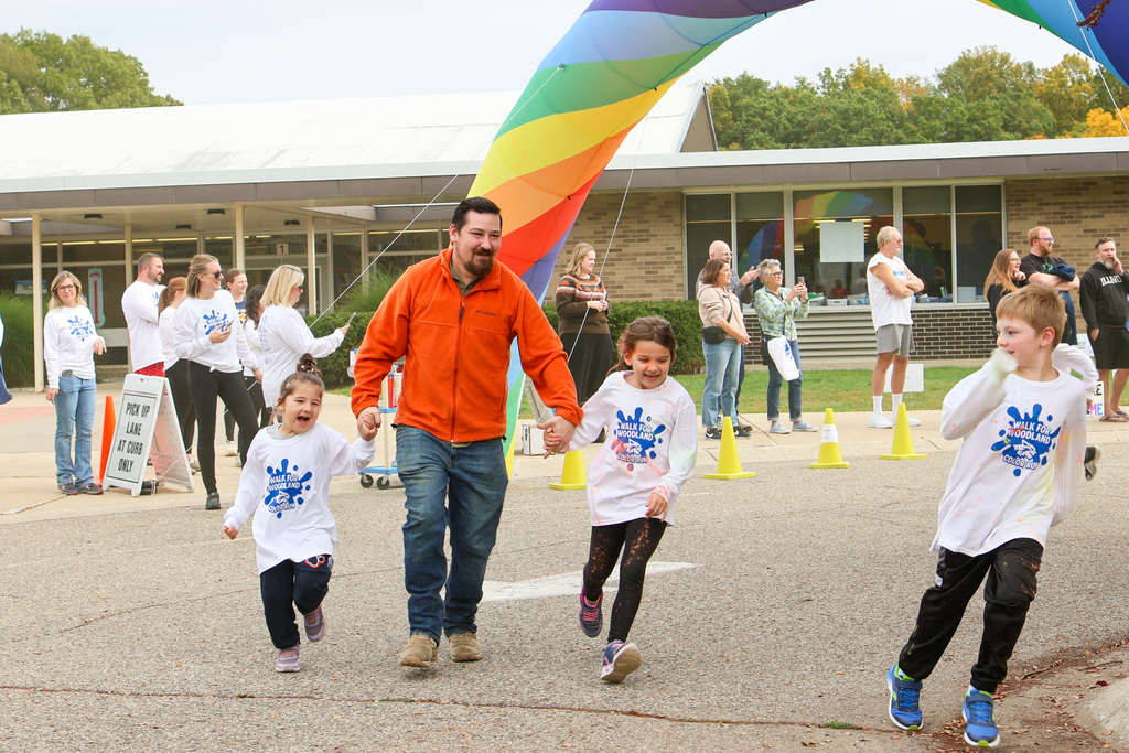 a man and two daughters running outside an elementary school