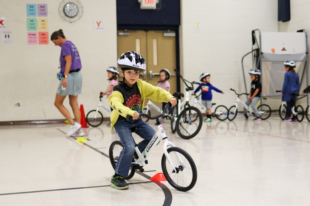 a boy riding his bikes in a school gym