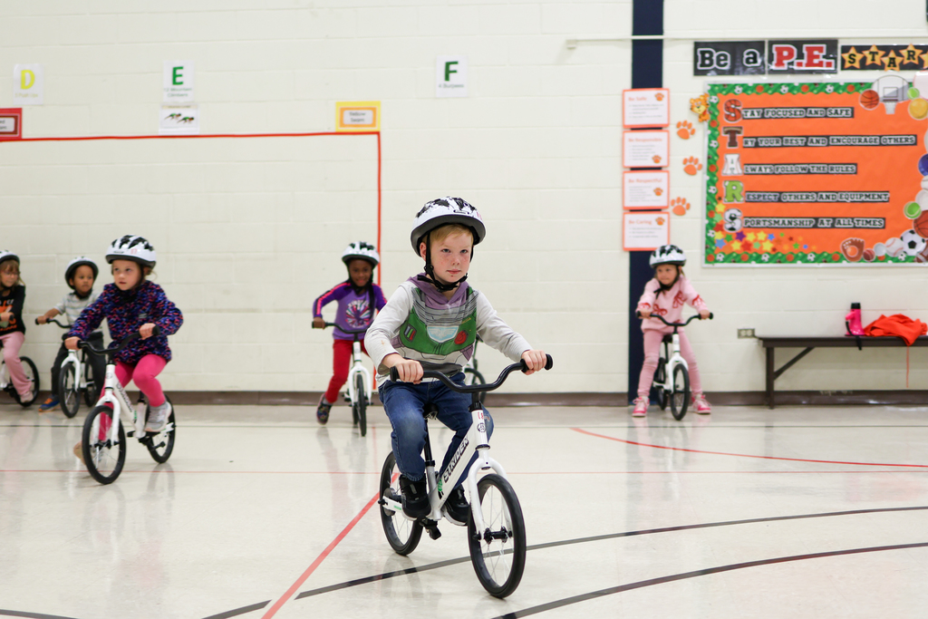 students riding bikes in a school