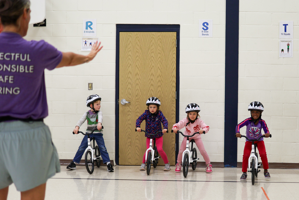 students riding bikes inside a gym