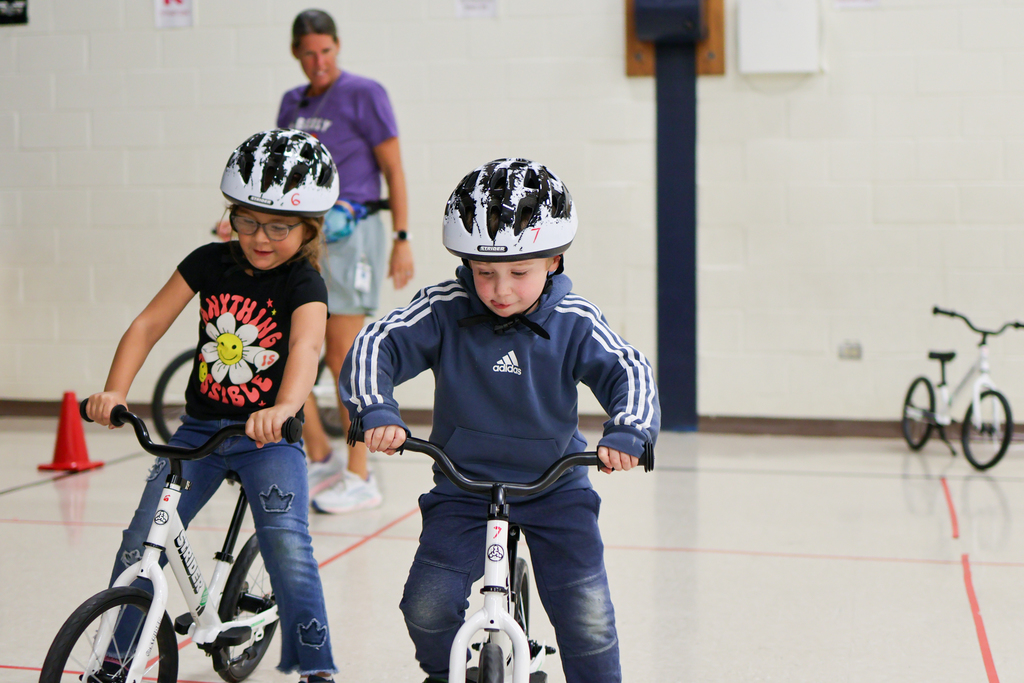 students riding bikes inside a gym