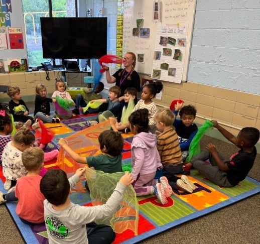 Students all playing with scarves at the carpet.