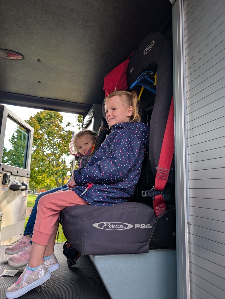 Two   year olds sitting in a fire truck.