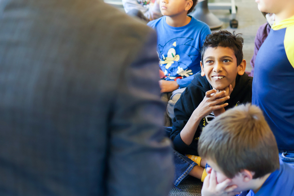 a boy smiles looking up at a man
