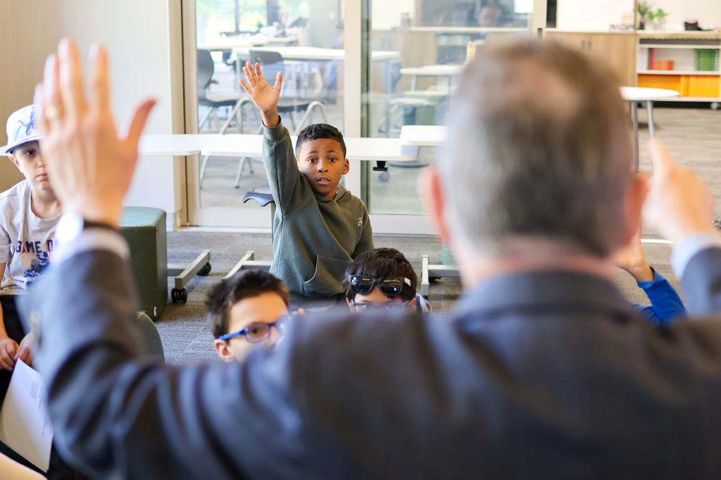 a boy raising his hand up 