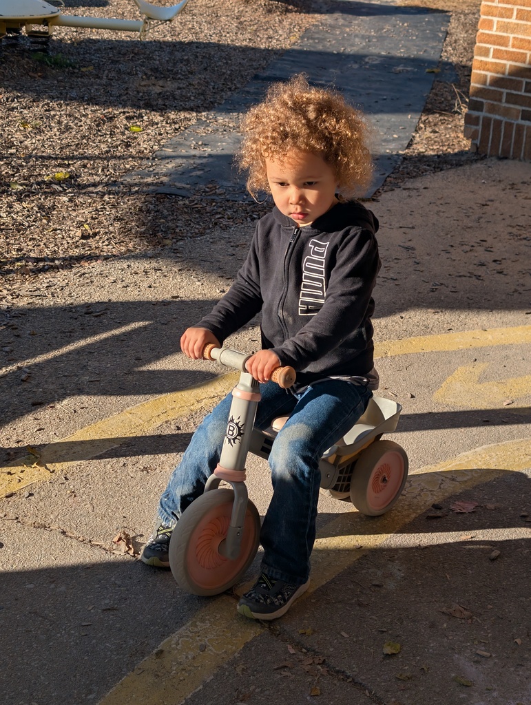 A student riding a balance bike,