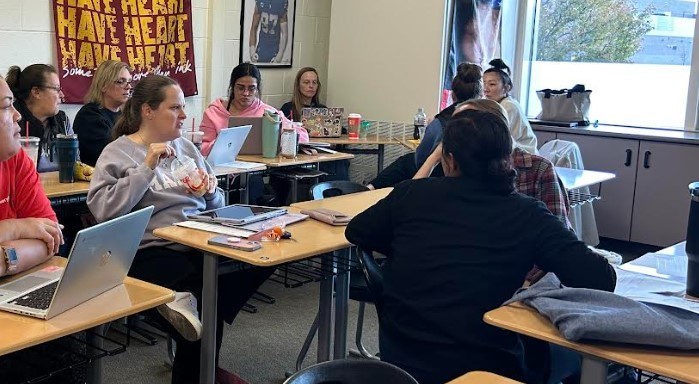 Teachers all sitting together in a classroom.