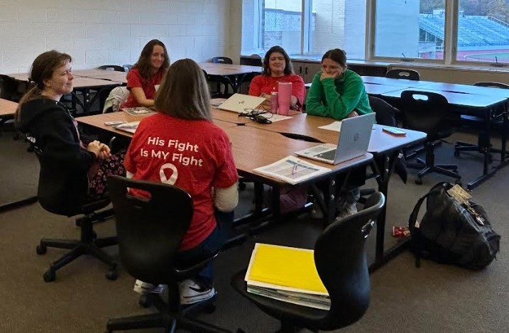 Team meeting with five females sitting together.