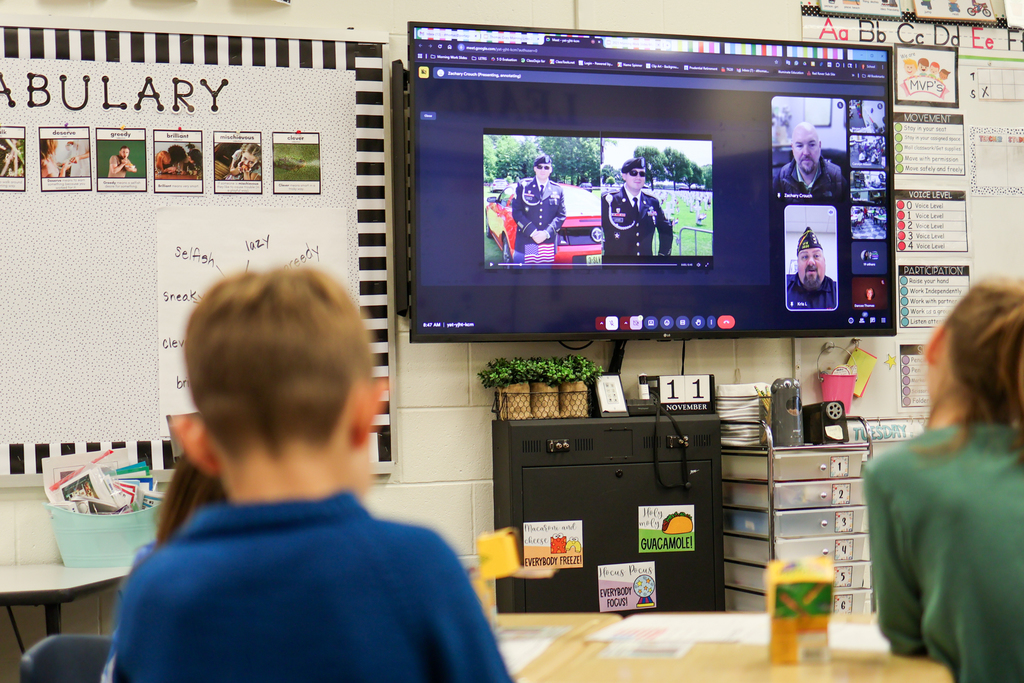 photos of army veterans projected on a tv screen in a classroom