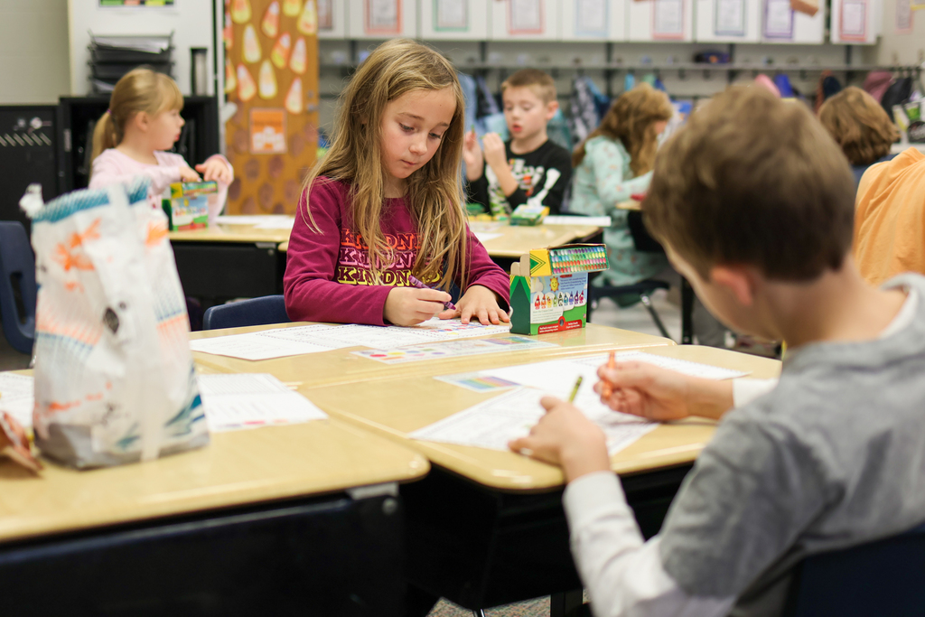 students in a classroom coloring at desks