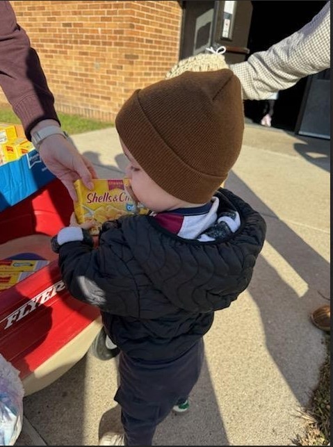 A boy carrying mac and cheese.