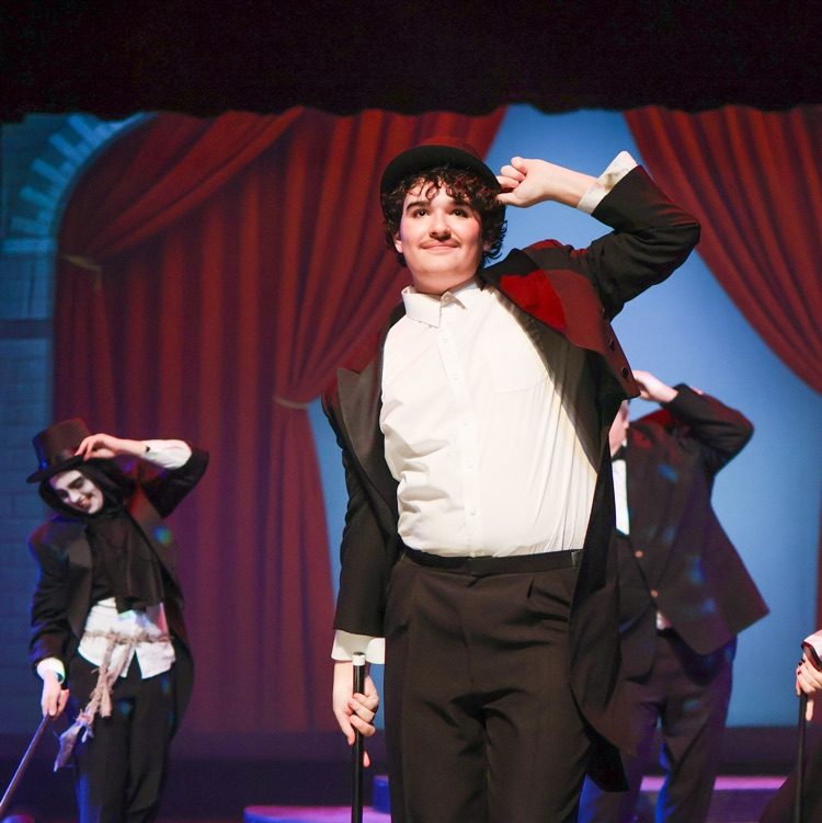 dancers in top hats perform a dance on stage