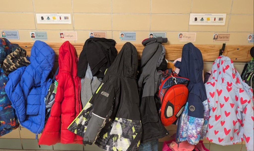 Row of coats and visual schedule in the hallway.