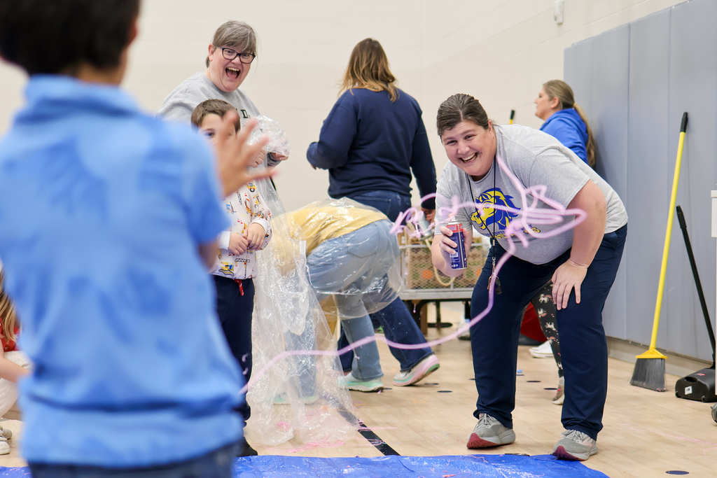 a teacher spraying a student with silly string