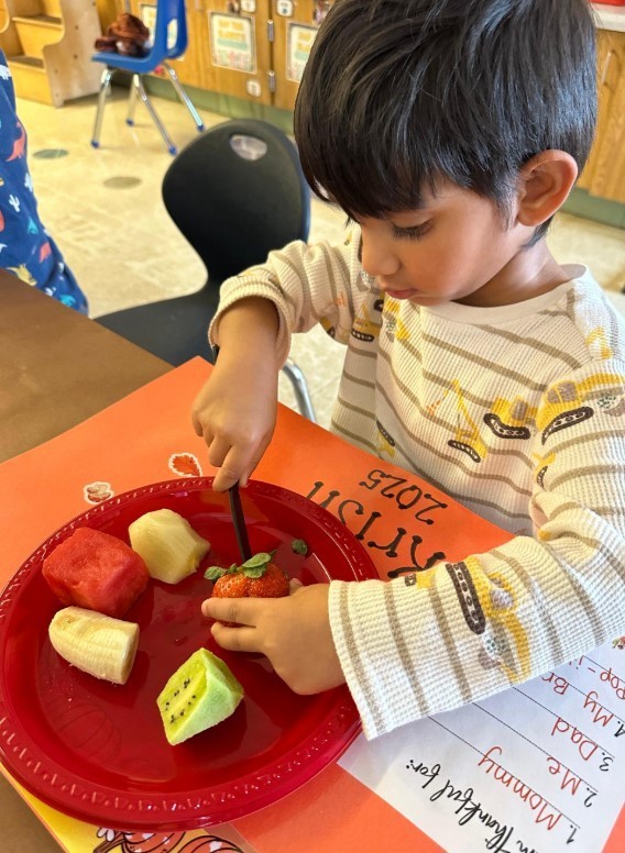 A male student cutting his own food.