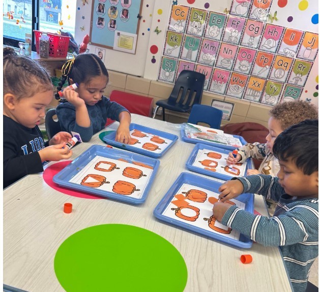 A gorup of students making pumpkin art.