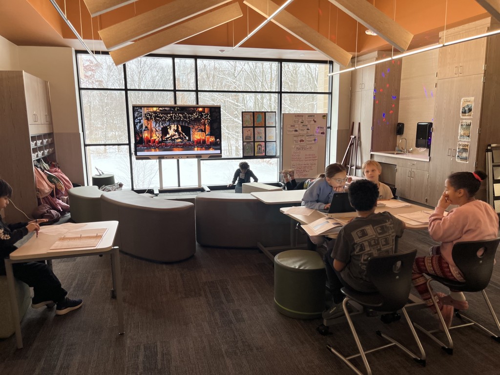 students working at desks in a common area of a school