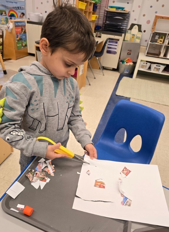 A male student cutting his own paper.