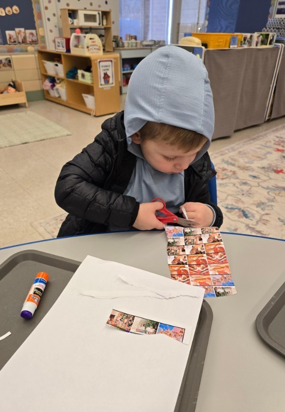 Student cutting at his table.