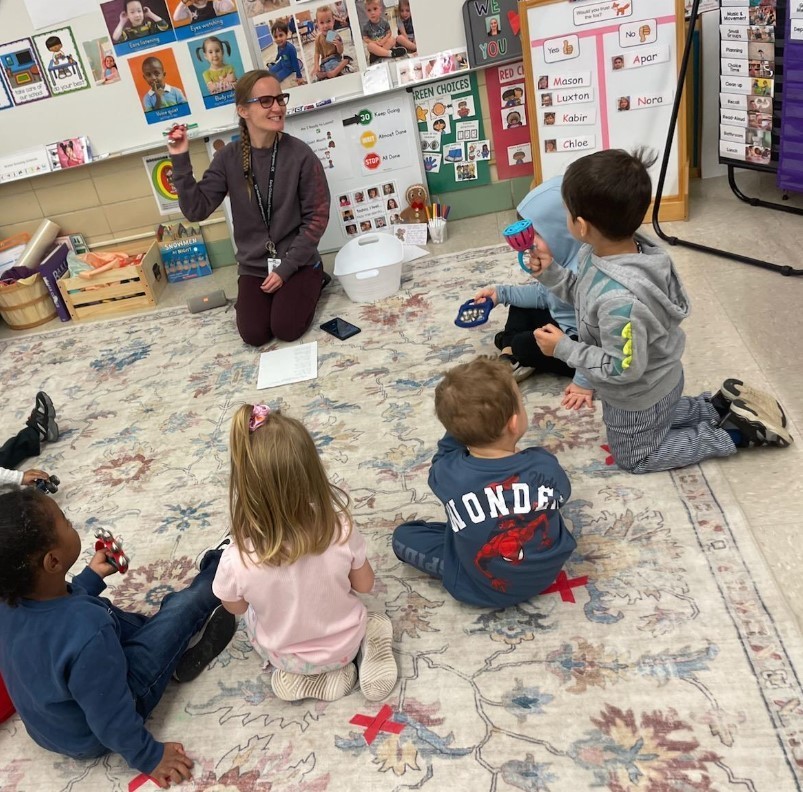 Students sitting in a circle at the carpet together.