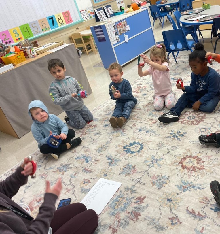 Students sitting in a circle togther at the carpet.