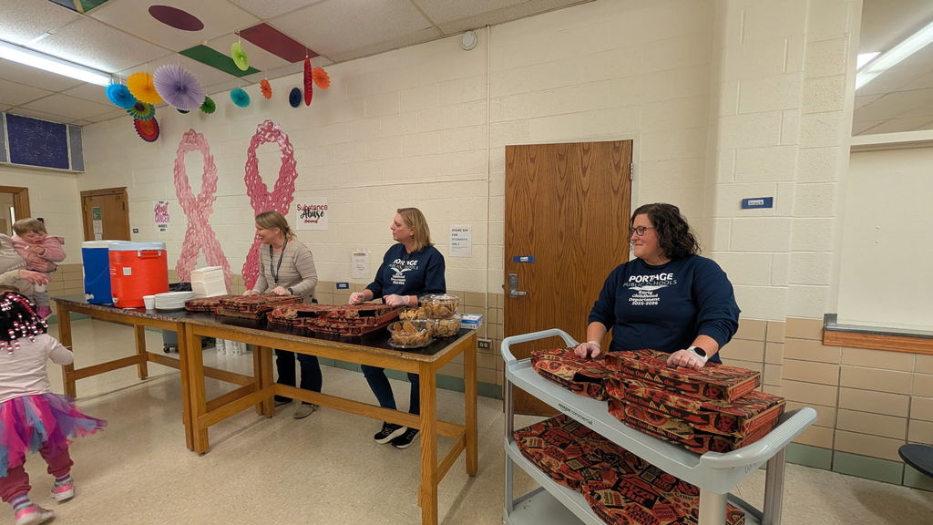 Staff members standing behind the pizza ready to pass it out.