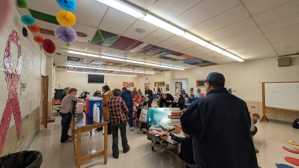 A view of the cafeteria where our families are enjoying pizza, cookies and each other.
