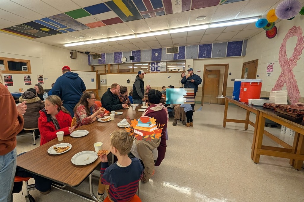A view of the cafeteria where our families are enjoying pizza, cookies and each other.