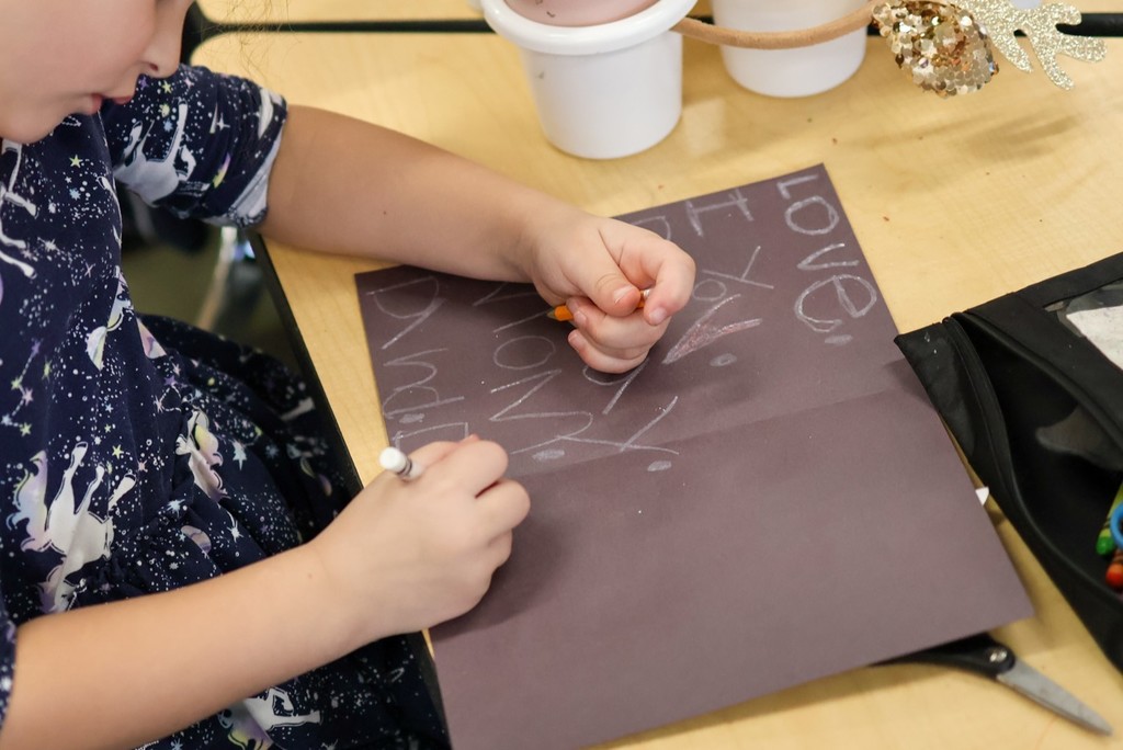 a student writing a letter at a school desk