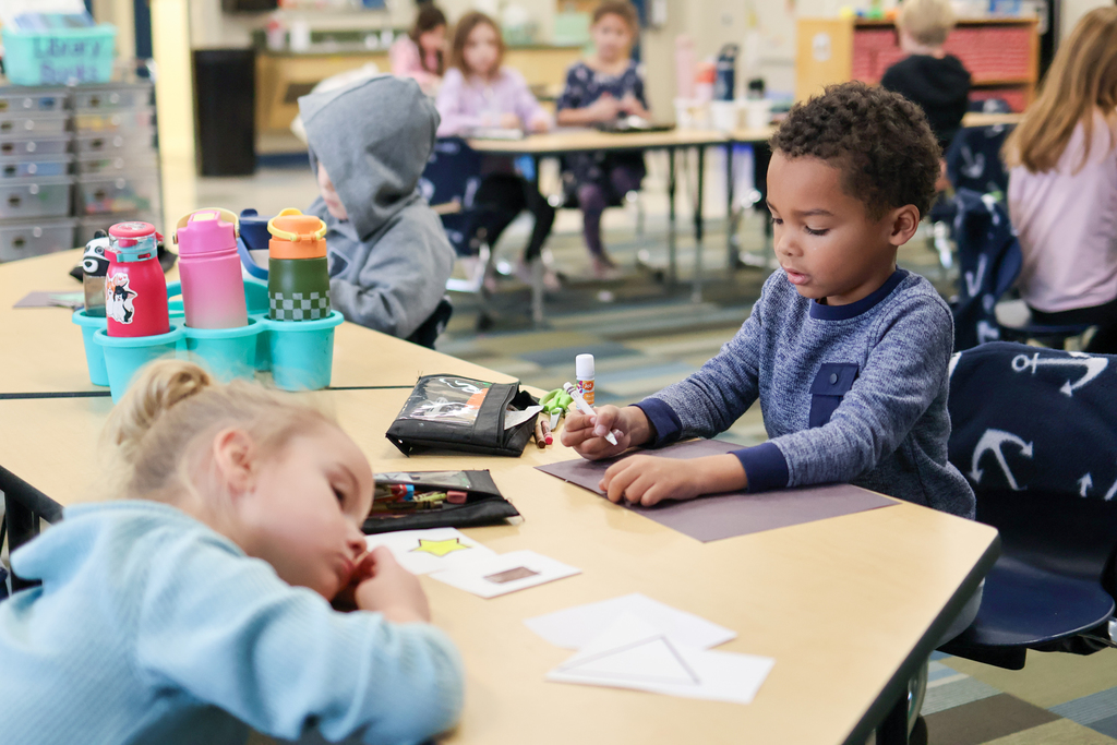 students working on cards at their desks in a classroom