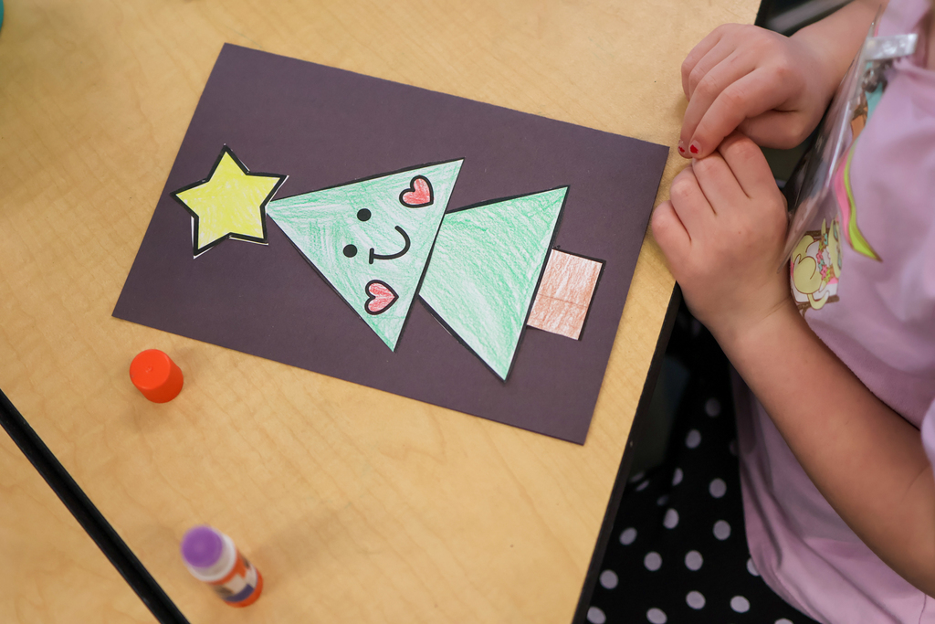 a card with a christmas tree sitting on a school desk