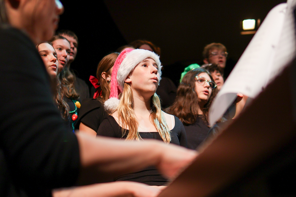 a girl in a santa hat performing on stage