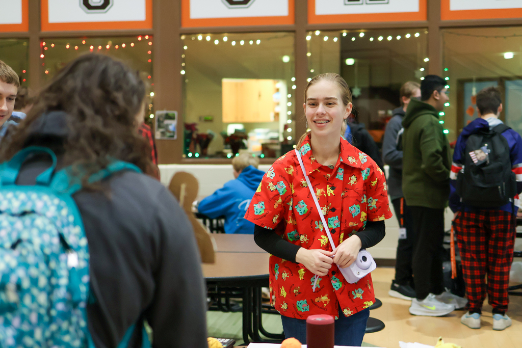 a student smiles at others in a cafeteria