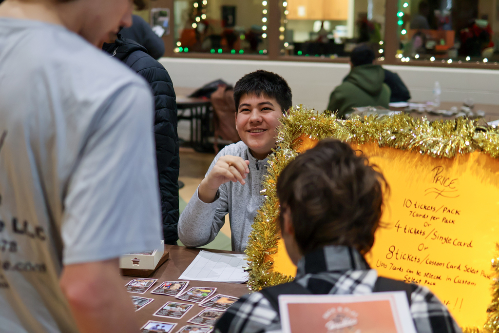 a boy smiles at others in a cafeteria