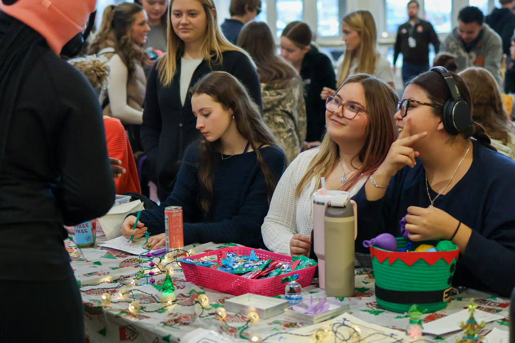 girls sitting in front of merchandise in a school cafeteria