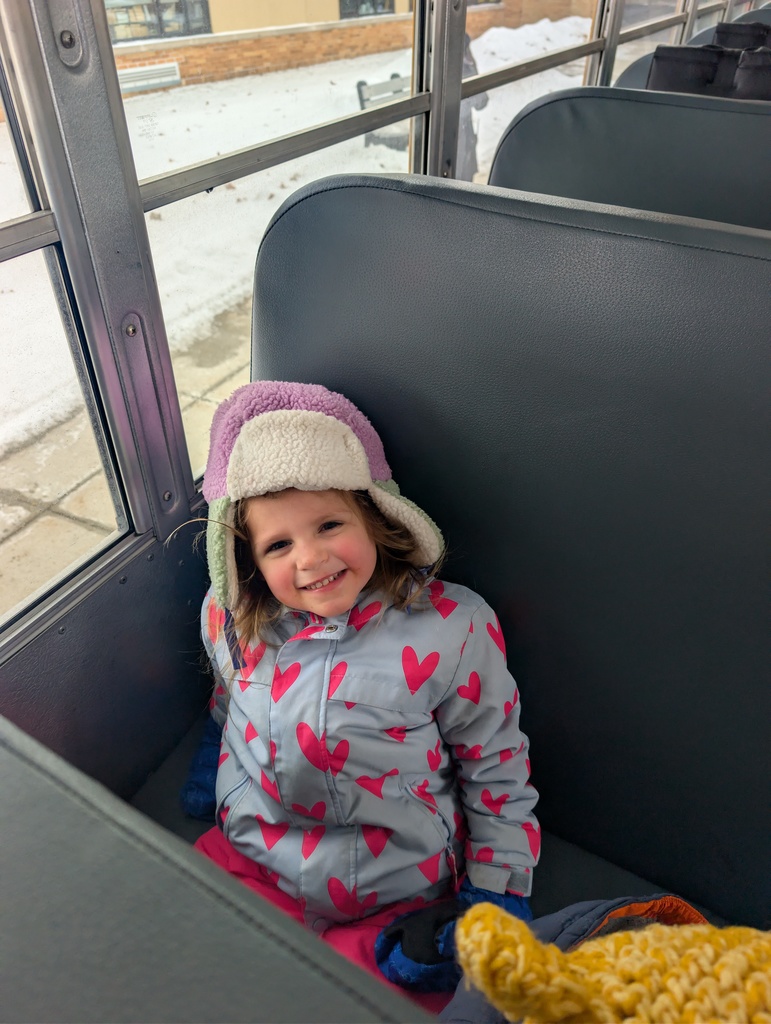 Student on a bus smiling.