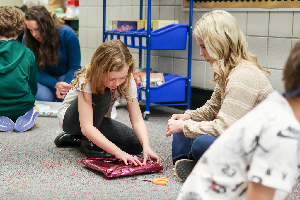 a girl wrapping a gift on the floor