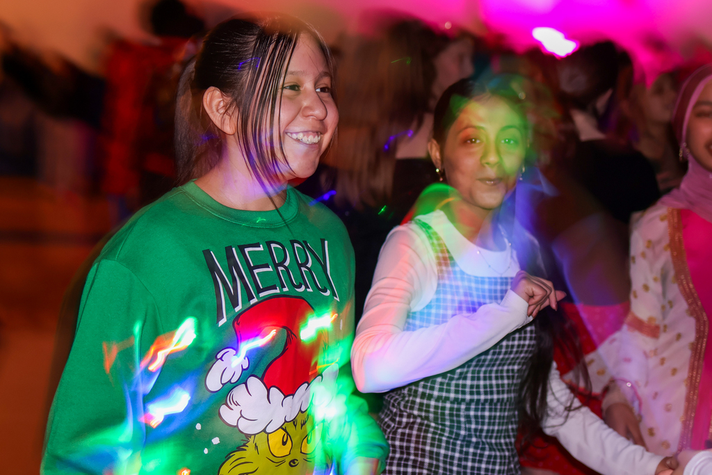 girls dancing under strobe lights on a dance floor