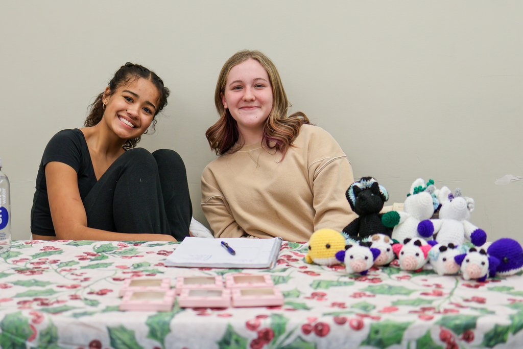 two girls pose with their crochet creations