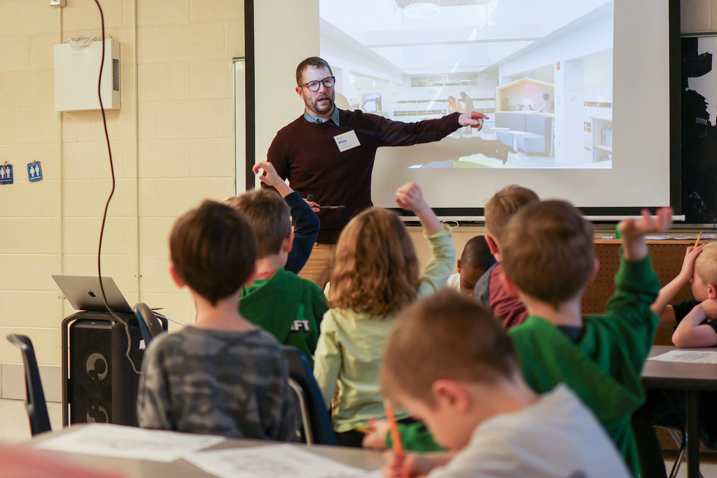 a man speaks to students in front of a presention