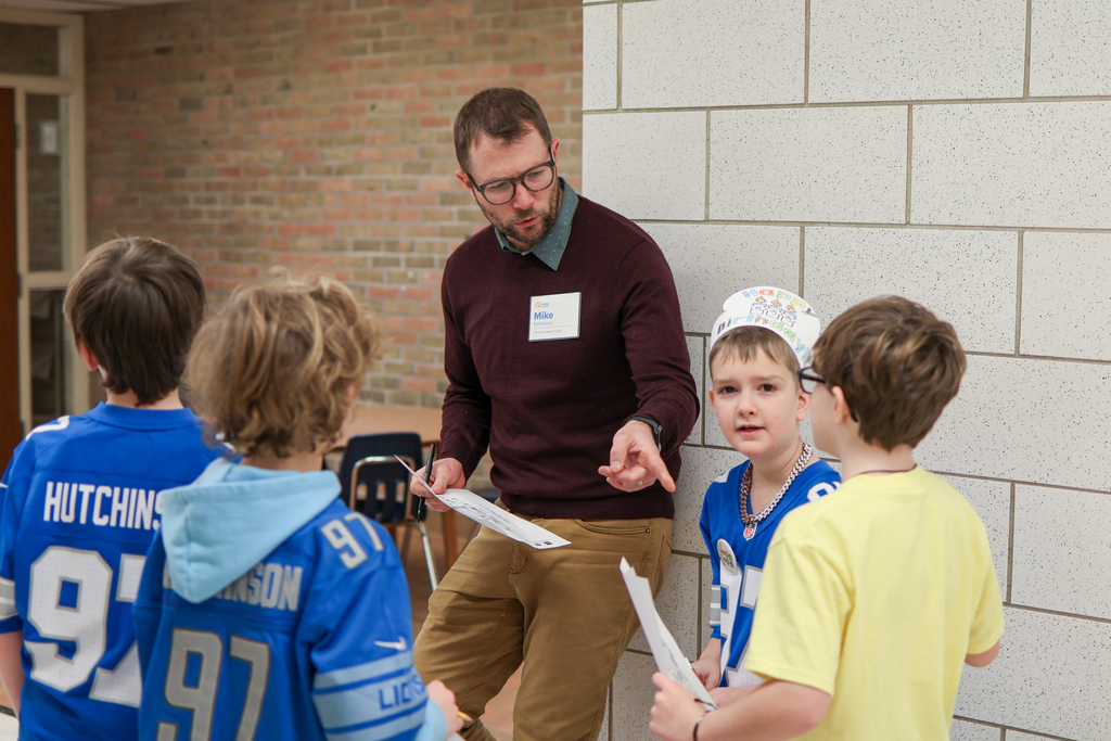 a man listens while a group of students talk