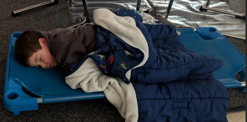 A student sleeping on a cot.