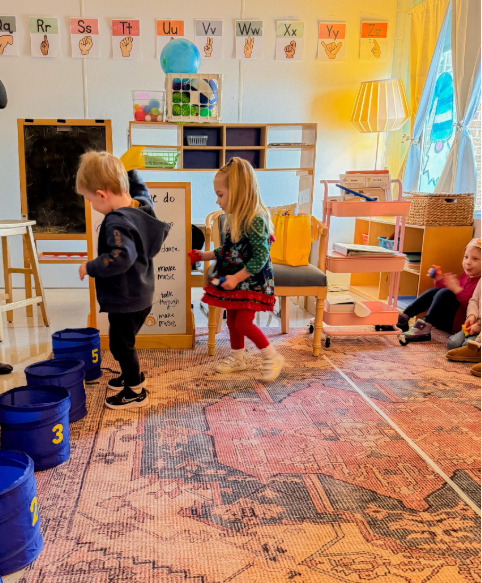 Students playing a game of bucket toss.