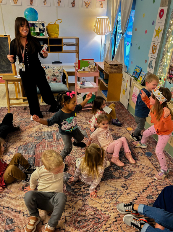 Students performing crab walks on the carpet together.