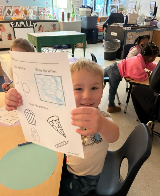 Little boy showing his worksheet.