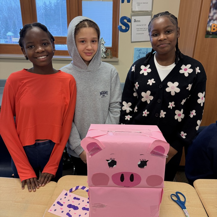 3 students with their cardboard pig