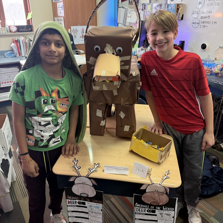 two students with a cardboard animal